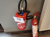 un extincteur posé à côté d'une bouche d'incendie sur le sol