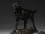 bronze sculpture of a dog standing on a log