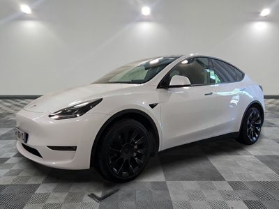La Tesla Model Y blanche est garée dans une grande pièce.