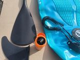 a blue surfboard and a paddle on the ground