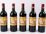 quatre bouteilles de vin sont alignées sur une surface blanche
