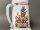 a white coffee mug with a floral design on it