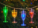 un gros plan sur une guirlande lumineuse sur laquelle sont posés des verres à vin