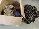 une boîte en carton remplie de vêtements posée par terre