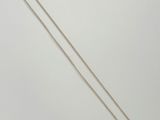 a white gold necklace with a single diamond on a chain