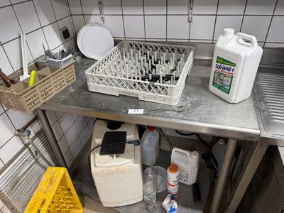 a metal counter with a bunch of dirty dishes on it