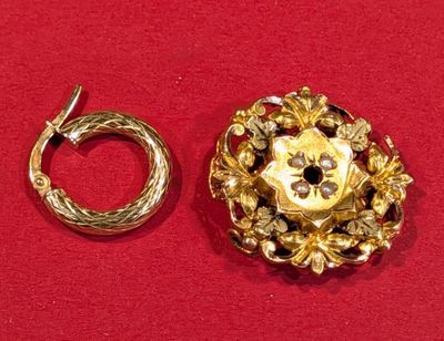 une broche en or et une bague en or sur un fond rouge