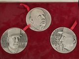 three commemorative medallions in a red box with a red ribbon around them