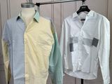two shirts hanging on a clothes rack in a room