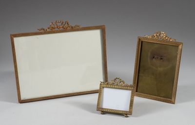 two gold picture frames are sitting next to each other on a white surface