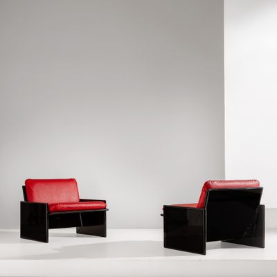 une paire de chaises noires et rouges dans une pièce blanche avec un mur blanc