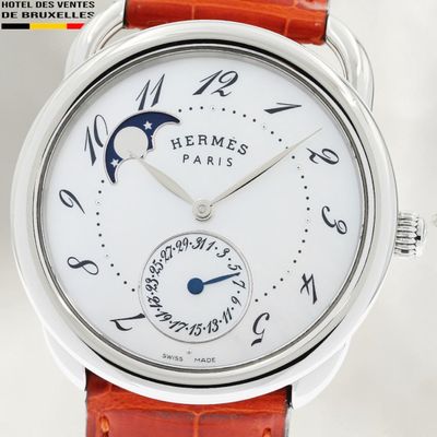 the watch has a white dial and a brown leather strap
