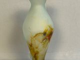 un vase blanc orné d'un motif marron et jaune