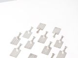 several pieces of metal are arranged in a square pattern on a white surface