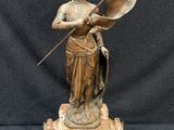 une image représentant une statue de femme tenant un drapeau et une horloge