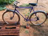a purple bike that is parked on a wooden pallet
