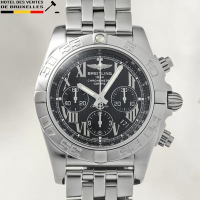 a close up of a stainless steel watch with a black dial