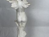 a statue of an angel sitting on a tree stump