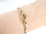 a woman ' s arm with a gold bracelet on it
