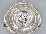 an antique silver plate with a flower design on the top