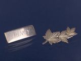 broche plaquée argent ornée d'une feuille et d'une plaque portant un nom