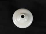 a white vase that is sitting on a black table