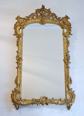 an ornate gold framed mirror on a white wall