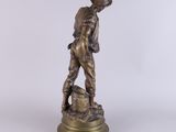 a bronze statue of a boy with a dog on a rock