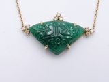 a close up of a necklace with a green stone on it