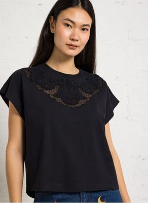 une femme portant un haut noir avec de la dentelle au niveau du cou