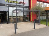 une devanture de magasin dotée d'une grande vitrine et d'un auvent rouge sur le côté du bâtiment
