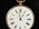 une montre de poche en or avec des chiffres romains sur le cadran