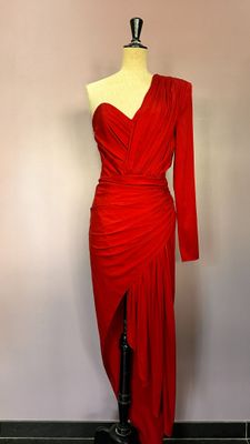 une robe rouge posée sur un mannequin devant un mur