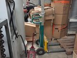 une pile de cartons et un diable dans un entrepôt