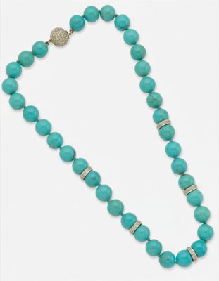 un collier de perles turquoise muni d'un fermoir en argent