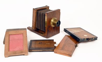 un petit appareil photo en bois à côté d'un petit cadre photo en bois