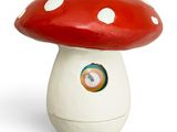 a red and white mushroom shaped object on a white surface