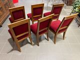 four red chairs sitting in a circle on a tile floor