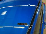 a close up of a blue car with a sticker on it