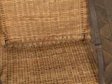 a wicker chair that is sitting on a wooden floor