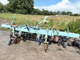 a blue plow that is sitting in the dirt