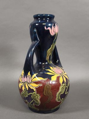 un vase bleu orné d'un motif rouge et jaune