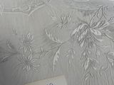 a picture of a bed with a white cover and a note on it