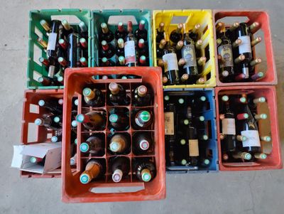 de nombreuses bouteilles de bière dans des récipients en plastique, par terre