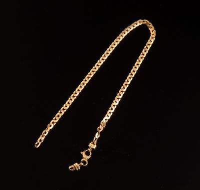 un collier plaqué or avec une chaîne sur fond noir