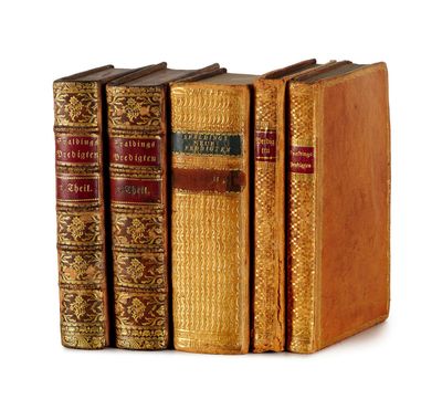 plusieurs vieux livres sont alignés sur une surface blanche