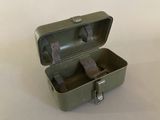 a small metal box with a handle on a white surface