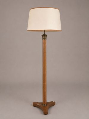 un lampadaire en bois surmonté d'un abat-jour blanc