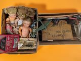 a box full of dolls and other items on a yellow surface