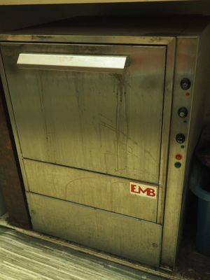 une porte métallique sur laquelle est accrochée une pancarte indiquant « emb »